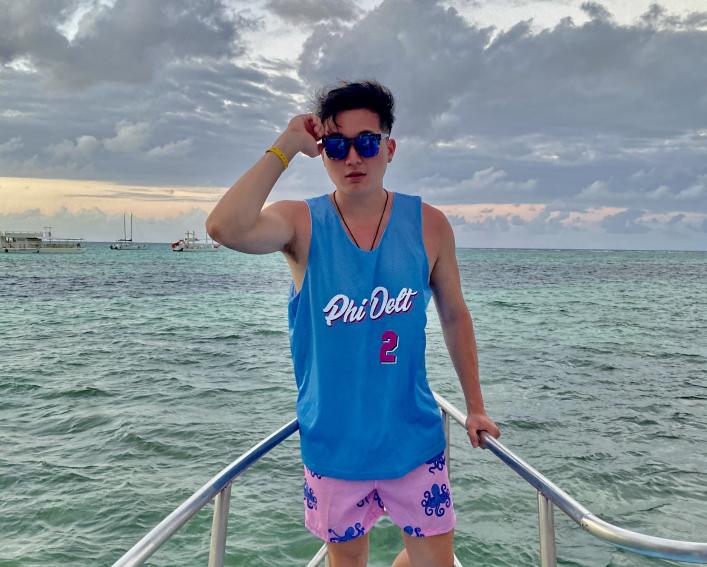 Brian Li on the bow of a boat