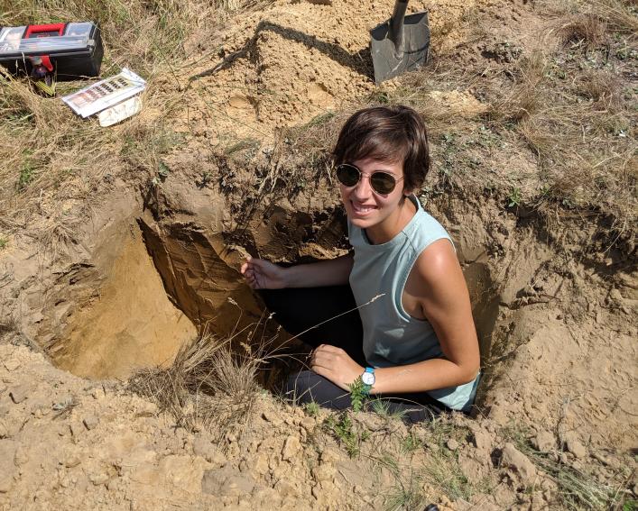 Isabella "Bella" Culotta standing in a hole dug into dirt