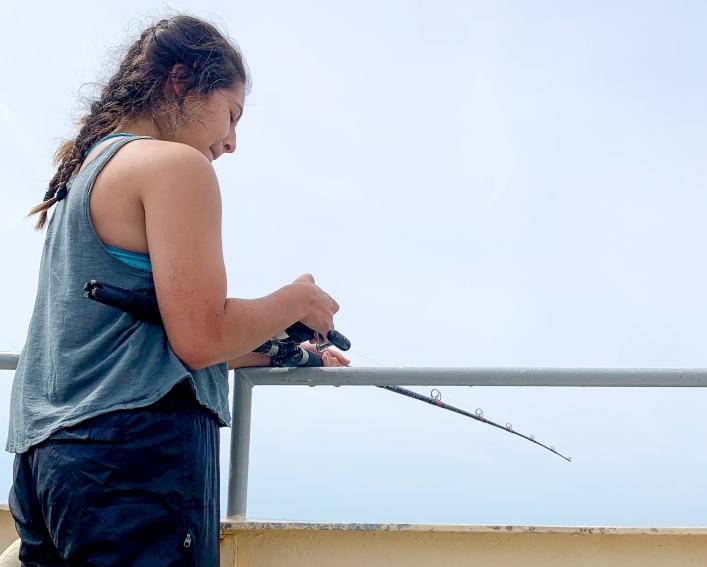 student with fishing pole