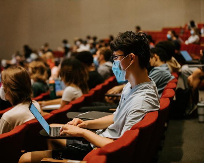 Students attend class in auditorium
