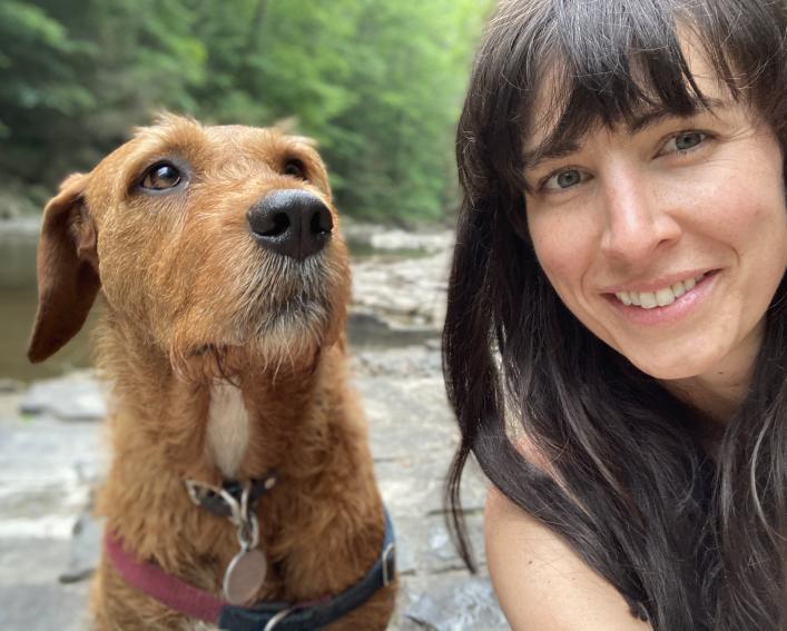 dog and woman by stream