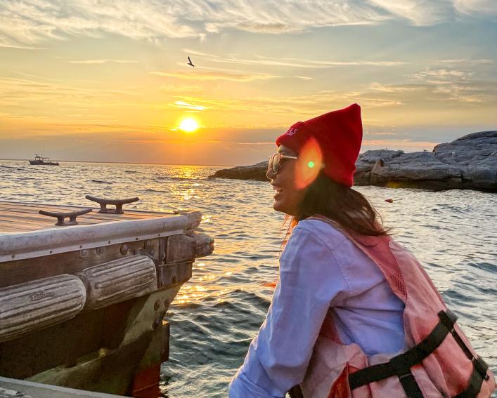 Lan Nguyen smiles in front of a sunset