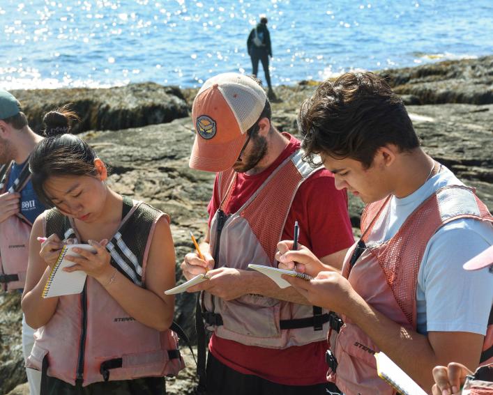 three students take notes