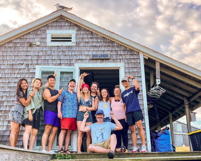group of people smile outside the underwater research center
