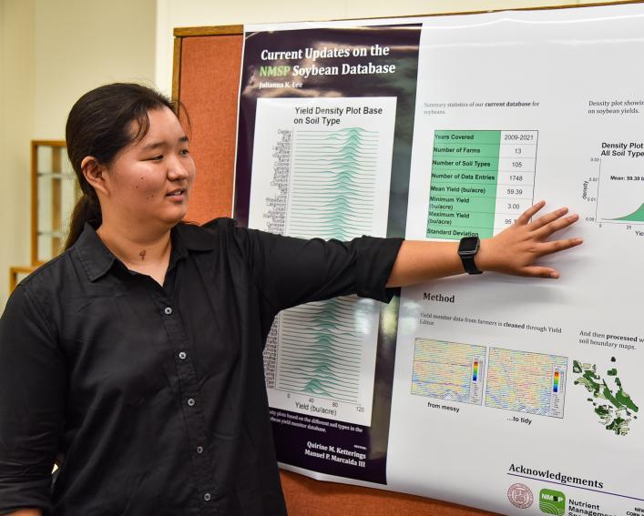 Julianna Lee points to poster
