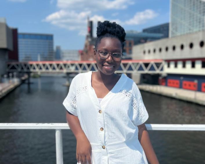 Girl standing on bridge in front of water
