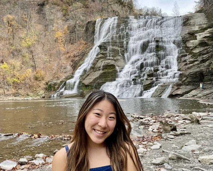 Girl standing in front of waterfall