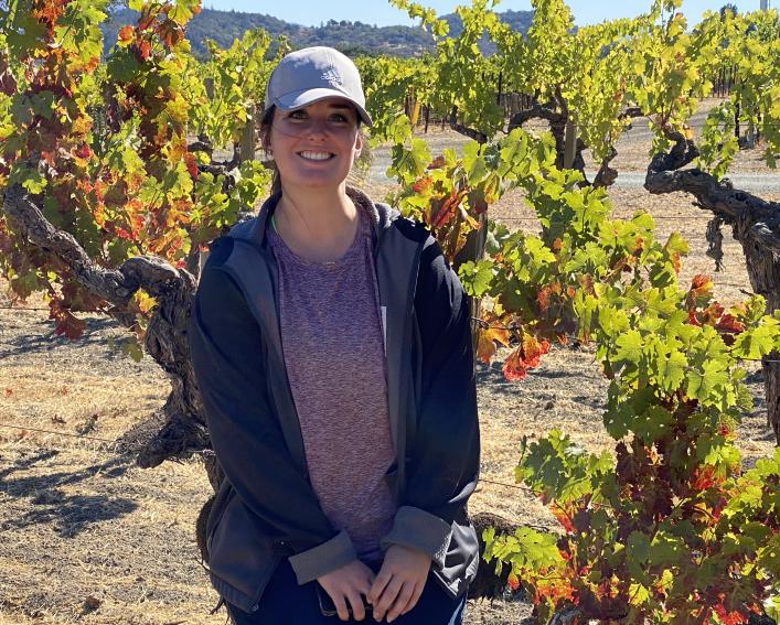 Maddie Flasco smiles in a California vineyard where she performed research.