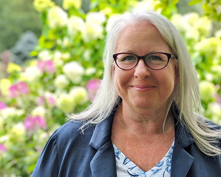sonja skelly with flowering shrubs in the background