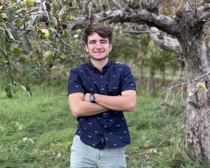 Griffin Erich standing in an apple orchard