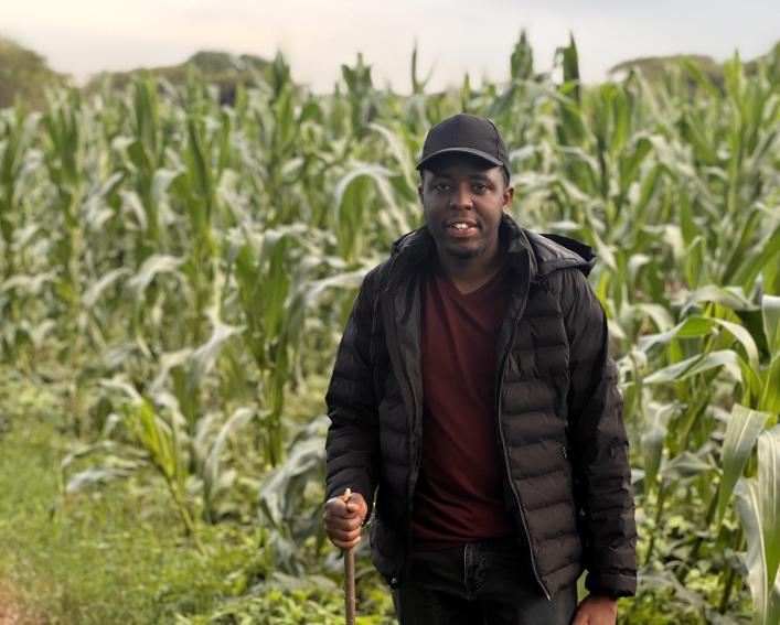 Jeff Kangacha standing next to a corn field 