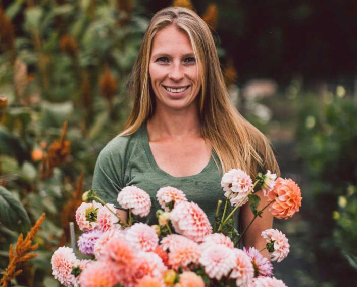 person smiling and holding a lot of flowers