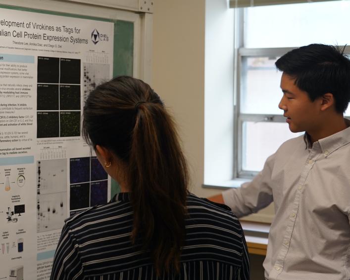 Man gesturing at research poster.