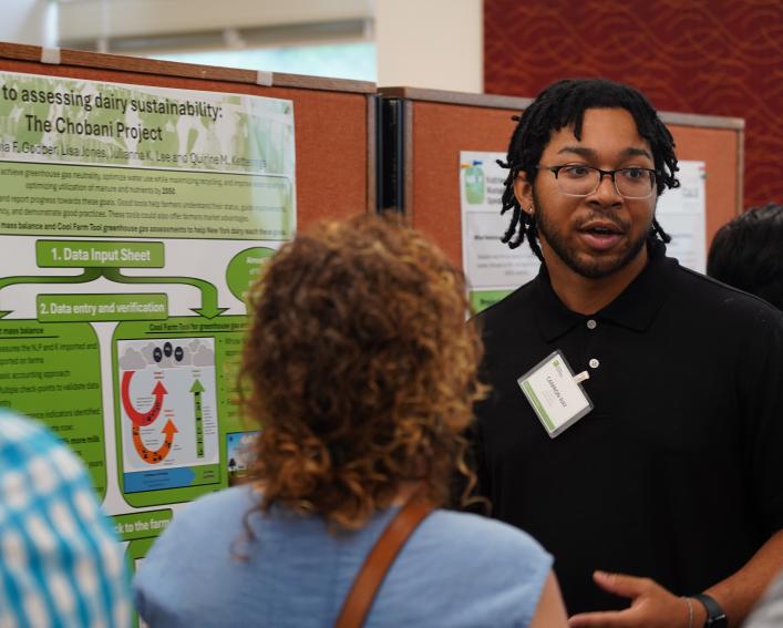 Man talking in front of a research poster.