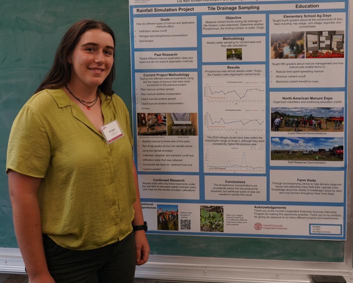 A woman smiling in front of a research poster.