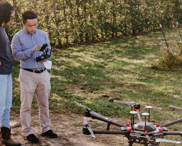 Yu Jiang operates a research drone with a graduate student.