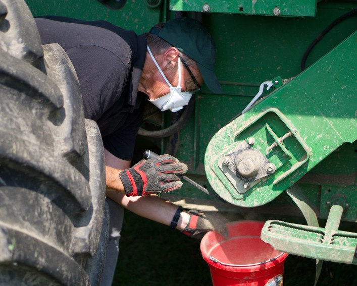person inspecting farm equipment