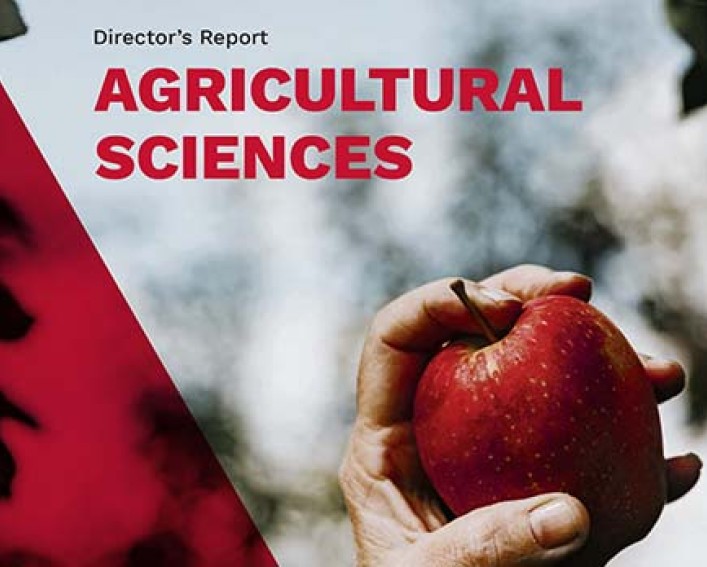 Ag Sci report cover featuring a hand holding a red apple
