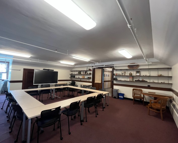 The AIISP Conference room, with a large rectangular table and shelves on the wall.