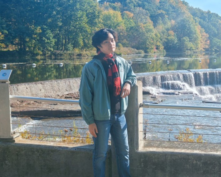 Student standing in front of waterfall