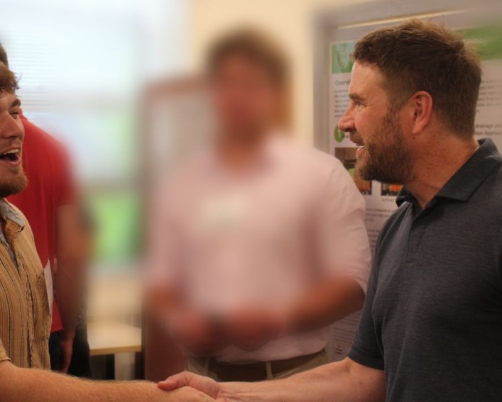 A man shakes hands with another man.