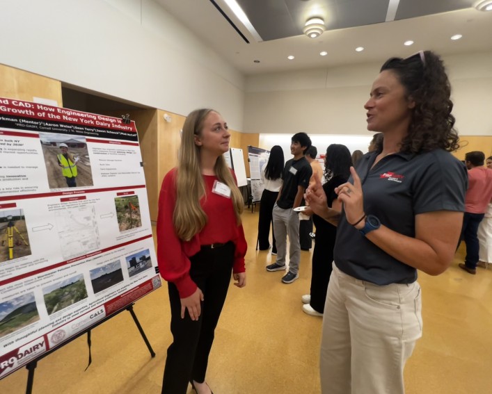 two people standing by a science poster
