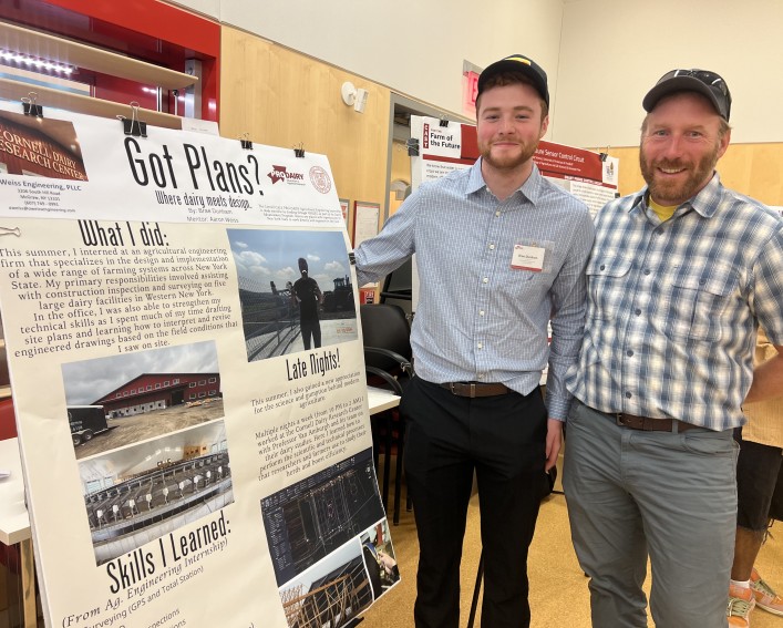 two people standing by a science poster