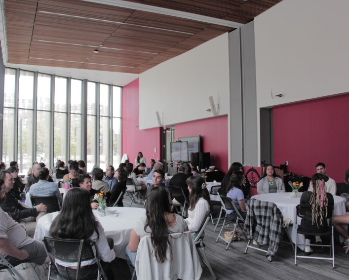 People sitting around tables in a large room.
