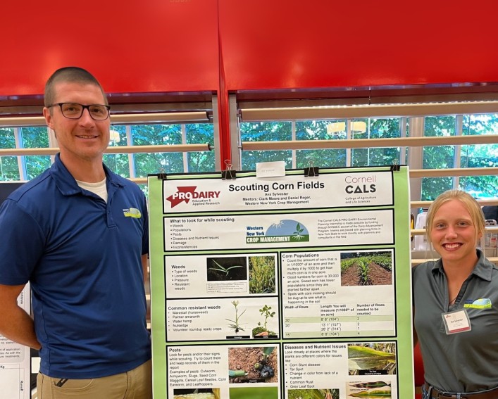 two people standing by a science poster