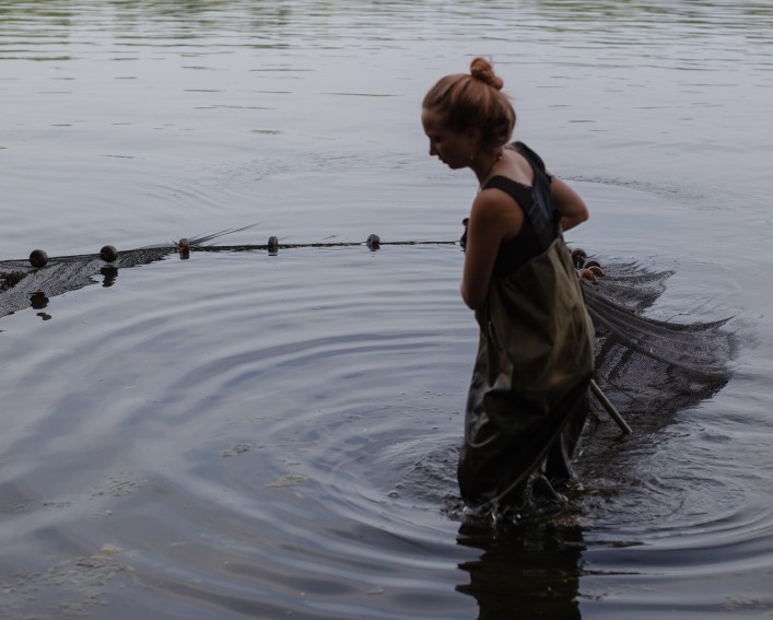 Person standing in a lake with a net