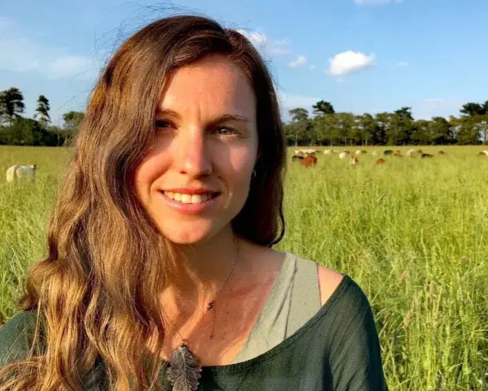 A headshot photo of Bryony Sands in a sunny field