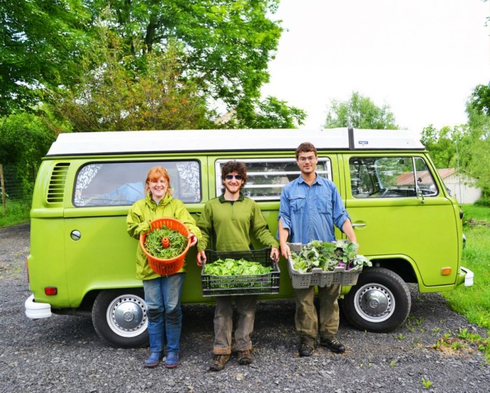 Three students with produce in front of a VW van