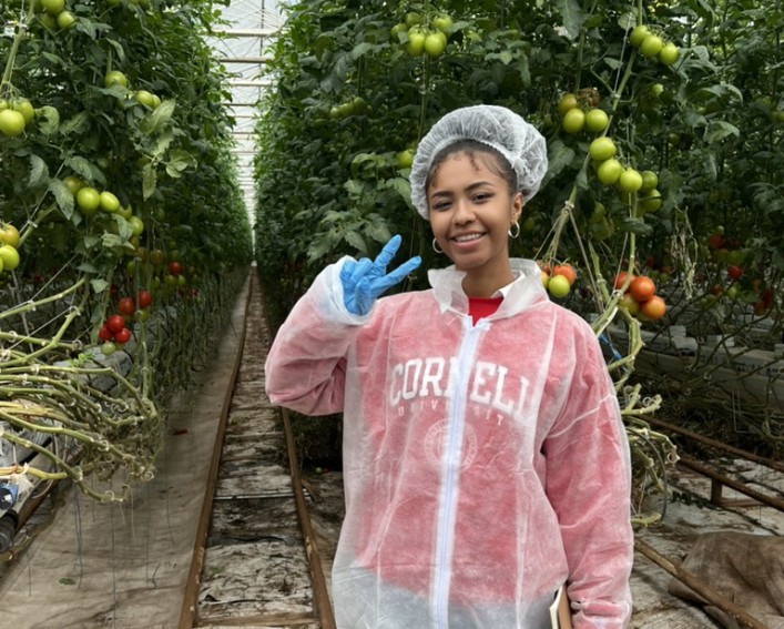Jamora with protective gear in a greenhouse