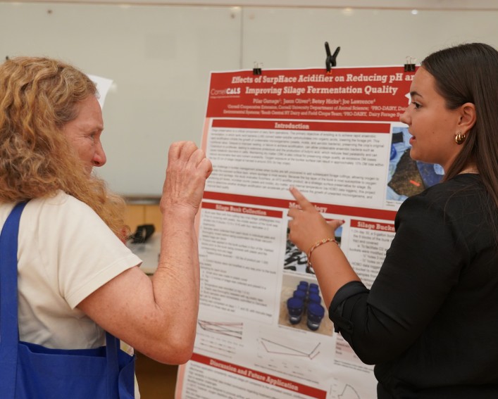Two women talk to each other, gesturing with their hands.