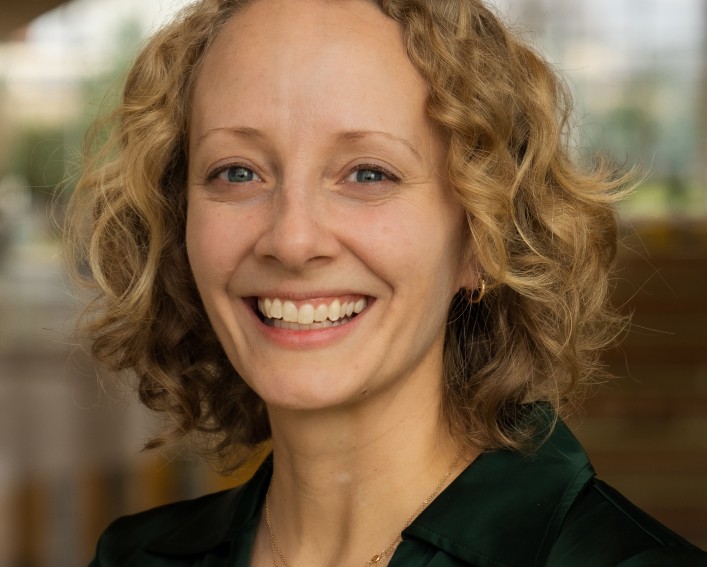 person smiles in front of blurred background