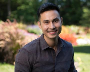 Marcos Simoes-Costa poses in a garden