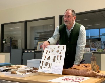 man at a table displaying plant samples