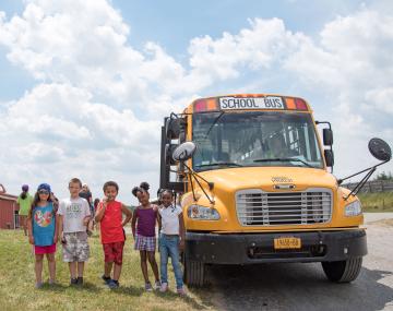 students posing for picture outside of bus