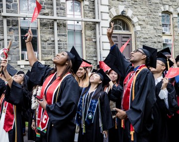 students waving at graduatino
