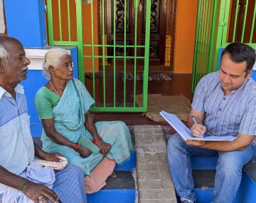 Researcher interviews two people in India