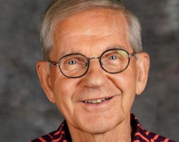 Person in a red shirt standing in front of a wall