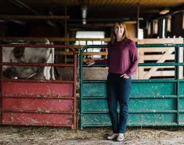 a woman stands in a barn