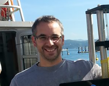 close up of a man with glasses on a boat