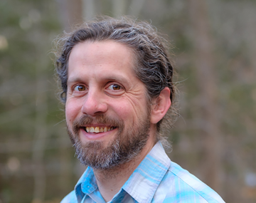 portrait of a man with a beard and a bright, checkered shirt