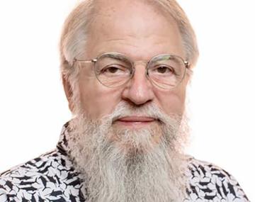 portrait of a man with white hair and a white beard in front of a white background