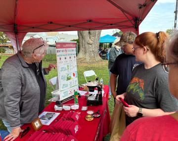 people having a conversation at an information table about ticks
