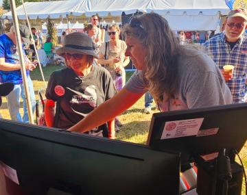 Person showing another person something at an outdoor event