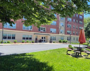 The exterior of a modern affordable housing apartment block, red and gray building