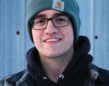 headshot of a person in a blue winter cap