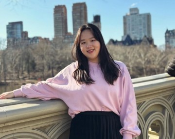 Girl standing in front of city buildings